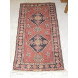 A Caucasian rug, the two central diamond medallions in dark blue,
