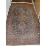 A Persian rug, the central panel set with floral decorated medallion on a blue ground,