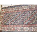 A Shirvan rug, the central repeating hook motifs in green, blue, terracotta, pale gold and cream,