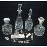 Four assorted cut glass decanters to include one with a silver collar together with a small