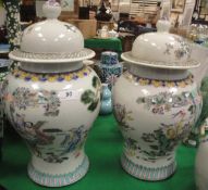 A pair of Chinese polychrome decorated baluster shaped vases and covers,