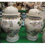 A pair of Chinese polychrome decorated baluster shaped vases and covers,