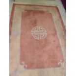 A modern Chinese super wash rug, the central panel set with Chinese symbol on a terracotta ground,