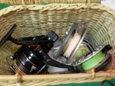 A small wicker basket containing two fly reels,