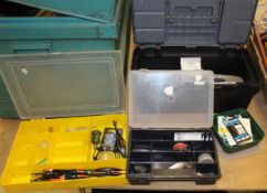 A collection of tackle boxes containing an assortment of fishing tackle to include spinners, flies,