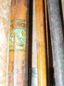 A collection of assorted vintage fishing rods and a snooker cue,