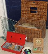 A wicker creel containing an assortment of fishing tackle to include a reel, floats,