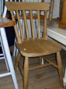 A pine Farmhouse style kitchen table, a set of four stained beech slat back kitchen chairs,