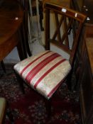 A set of four Edwardian mahogany and inlaid dining chairs with upholstered seats on square tapered