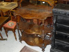 A Victorian burr walnut three tier serpentine fronted whatnot with mirrored back
