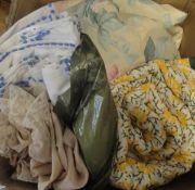 A box containing two circular table cloths, the yellow ground with floral design,