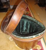 A leather hat box of typical form opening to reveal a green silk lining,