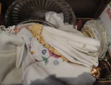 A box containing assorted vintage table linens together with vintage tea plates,