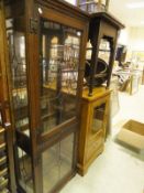 A modern oak two door display case with leaded glass and mirrored back together with a further oak