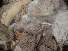 A box containing assorted vintage doilies,
