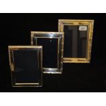 A graduated pair of modern silver photograph frames with reeded and ribbon decoration (by Carrs of