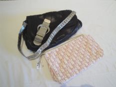 A black leather Dior handbag with metal strap and cotton protective bag and a Dior make-up bag