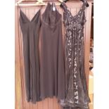 A collection of three black evening gowns, one with a heavily sequinned pattern,