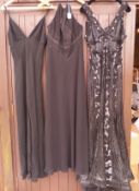 A collection of three black evening gowns, one with a heavily sequinned pattern,