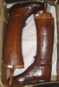 A pair of brown leather riding boots with wooden trees