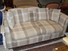An Arcateura two seat sofa in pale cream and beige upholstery