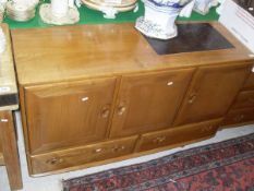 An Ercol elm dwarf side cabinet with three cupboard doors over two drawers CONDITION