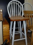 A set of three painted pitch pine stick back kitchen high stools on turned supports united by