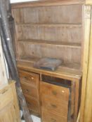 A Victorian pine dresser with two tier boarded plate rack over two cupboard doors as two banks of