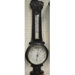 A Victorian carved oak cased aneroid barometer thermometer