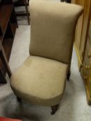 A Victorian nursing chair with neutral upholstery, turned legs to brass and china castors,