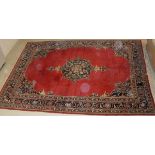 A Persian carpet, the central panel set with central flowerhead designed medallion on a red ground,