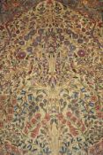 A Tree of Life design rug, the central panel set with tree and floral motifs on a fawn ground,