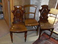 A pair of Victorian oak panel seated hall chairs with pierced medallions backs and a cane seated