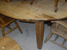 An oval planked pine topped kitchen table on square sectioned legs