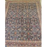 An Eastern rug, the central panel with all over foliate decoration on a midnight blue ground,