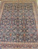 An Eastern rug, the central panel with all over foliate decoration on a midnight blue ground,