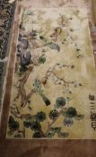 A Chinese silk rug, the central panel set with scene of birds amongst branches and blossoms,