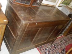 A 19th Century oak coffer or feed bin with panelled top over a three panel front on styled supports