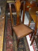 A set of four mahogany and inlaid dining chairs with pinched splat back above a drop-in seat on