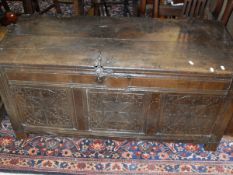 A circa 1700 oak coffer with three carved panels to the front,