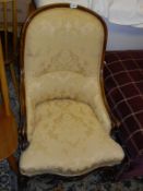 A Victorian mahogany framed salon chair in a pale yellow self patterned upholstery,