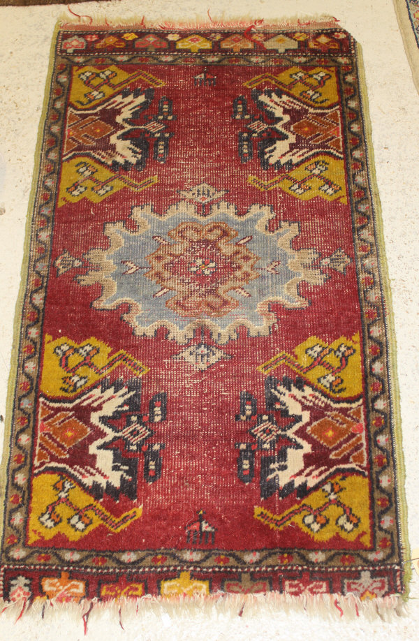 A Caucasian rug, the central panel set with a stylised flower head medallion on a mushroom ground, - Image 2 of 3