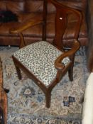 A mahogany framed carver chair with cream ground green leaf patterned upholstered seat,