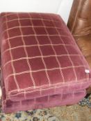 A footstool in plum fabric by Osborne & Little