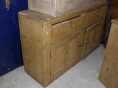 A pine dresser with two drawers over two cupboard doors
