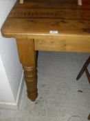 A pine rectangular kitchen table on turned supports