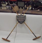 A reproduction Polo trophy in the form of two mallets crossing with shield shaped plaque inscribed