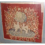 A woolwork study of a unicorn and gryphon against an orange tree set upon a red floral decorated
