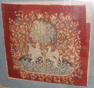 A woolwork study of a unicorn and gryphon against an orange tree set upon a red floral decorated