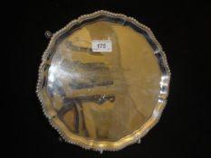 A mid 20th Century Edwardian silver salver with dragooned edge and raised on four hoof feet (London